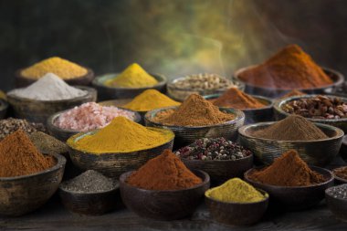 Mutfak masasında çeşitli baharatlar ve otlar var.