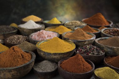 Mutfak masasında çeşitli baharatlar ve otlar var.