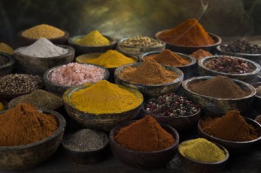 Mutfak masasında çeşitli baharat ve bitkiler var.