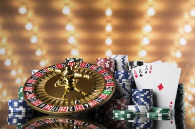 Kumar masasında poker fişleri, hareket halindeki rulet çarkı, kumarhane geçmişi