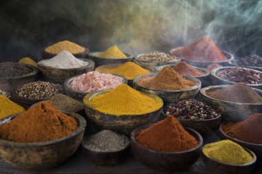 Mutfak masasında çeşitli baharat ve bitkiler var.