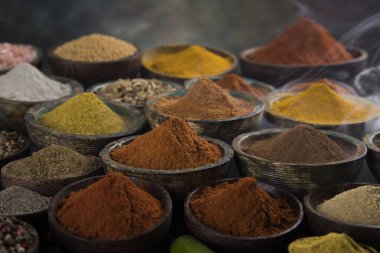 Mutfak masasında çeşitli baharatlar ve otlar var.