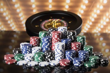 Kumar masasında poker fişleri, hareket halindeki rulet çarkı, kumarhane geçmişi