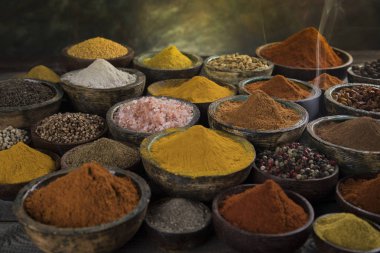 Mutfak masasında çeşitli baharat ve bitkiler var.