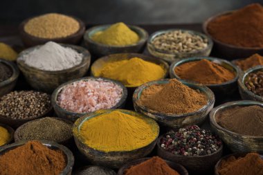 Mutfak masasında çeşitli baharat ve bitkiler var.