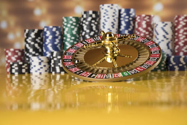 Poker Chips on gaming table, roulette wheel in motion, casino background