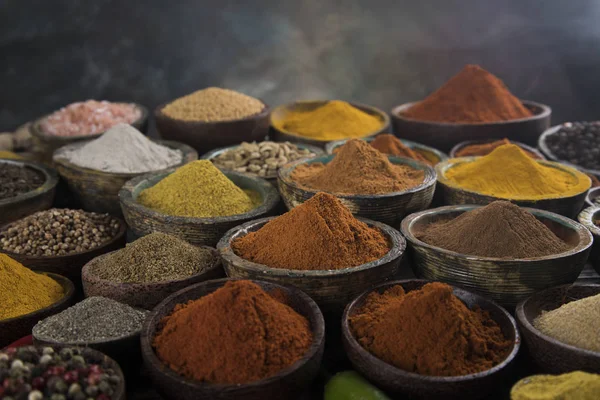 Mutfak masasında çeşitli baharatlar ve otlar var.