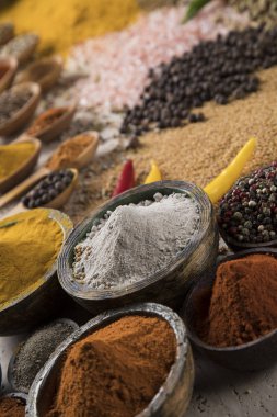 Mutfak masasında çeşitli baharat ve bitkiler var.