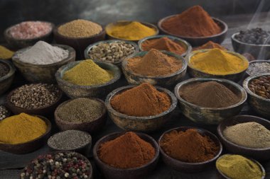 Mutfak masasında çeşitli baharat ve bitkiler var.