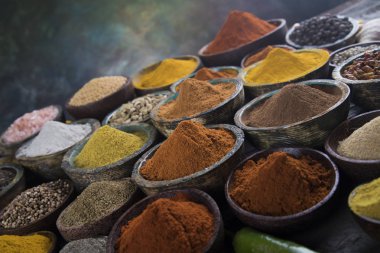 Mutfak masasında çeşitli baharat ve bitkiler var.