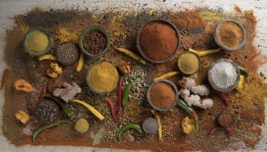 Mutfak masasında çeşitli baharat ve bitkiler var.