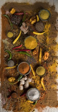 Mutfak masasında çeşitli baharat ve bitkiler var.