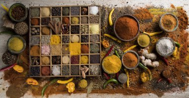 Mutfak masasında çeşitli baharat ve bitkiler var.