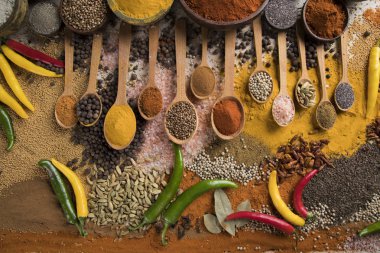 Mutfak masasında çeşitli baharat ve bitkiler var.