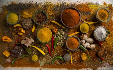 Mutfak masasında çeşitli baharat ve bitkiler var.