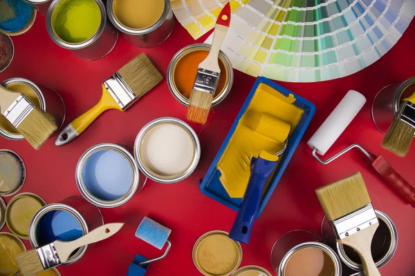 Open buckets with a paint and brush, red background