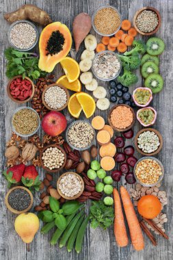 Healthy high fibre super food with fruit, vegetables, pulses, nuts, seeds, cereals and grain with foods high in antioxidants, anthocyanins, omega 3 fatty acids and vitamins. Top view. clipart