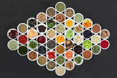 Porselen sağlıklı süper gıda kavramı artırılması beyin arduvaz arka plan üzerinde kaseler. Gıdalar antioksidanlar, omega 3, Antosiyaninler, mineraller ve vitaminler yüksek.