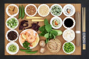 Makrobiyotik Japon yemekleri Deniz ürünleri, Suşi, miso ve wasabi Yapıştır ve fındık, soya peyniri, kuchika çay, sebze, soba noodle, soya, soya gıdalar yüksek protein, antioksidanlar, vitaminler ve mineraller ile konseptiyle. Bambu ve slae arka plan üzerinde görünümü top.