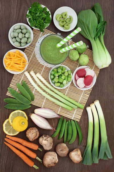 Japanese macrobiotic diet food concept with cold matcha tea, wasabi paste and nuts, fresh vegetables, fruit and   with foods high in antioxidants, fibre, vitamins and minerals. On bamboo and oak, top view.