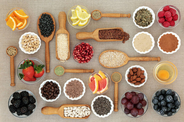 Health food for dieting concept with nutritional powder, supplements, fruit, pulses, nuts, cereals and grains including herbs used as appetite suppressants. Super foods high in omega 3, antioxidants, fiber and vitamins.  