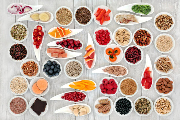 Health food for a healthy heart with fish, vegetables, fruit, nuts, seeds, pulses, spice and medicinal herbs. Superfood concept. High in omega 3 fatty acid, smart carbhydrates, antioxidants, minerals and vitamins.