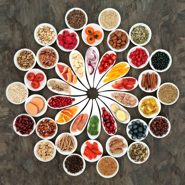 Large health food collection for a healthy heart with fruit, fish, vegetables, nuts, seeds and cereals with spices and herbs also used in herbal medicine. High in omega 3 fatty acid, anthocyanins, fiber, antioxidants and vitamins.