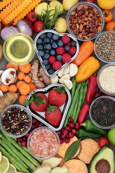 Healthy diet food concept of fruit, vegetables, herbs, spice, grains, nuts, seeds, olive oil and himalayan salt. Super foods high in antioxidants, fiber, smart carbohydrates, vitamins, minerals and anthocyanins.