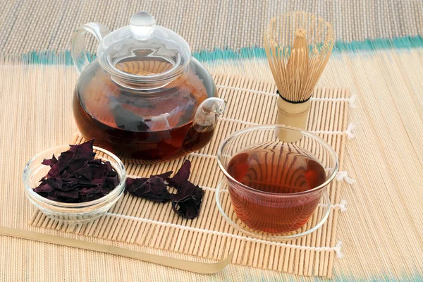 Dulse 海藻茶保健饮料与玻璃茶壶和茶杯和干燥的叶子 搅拌和搅拌器的竹子背景 矿物质含量高 — 图库照片