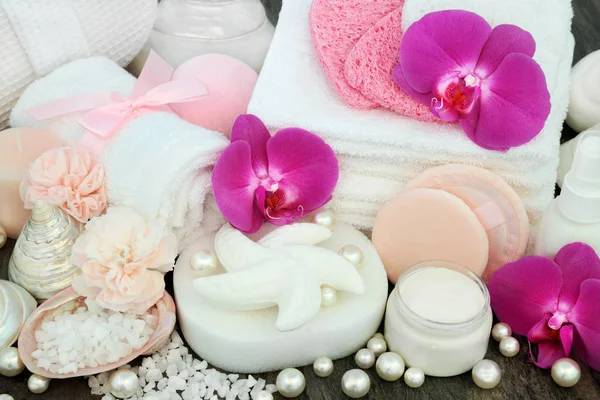 美容水疗产品包括贝壳形肥皂 保湿奶油 兰花和康乃馨花 身体化妆水与装饰贝壳和珍珠大理石背景 — 图库照片