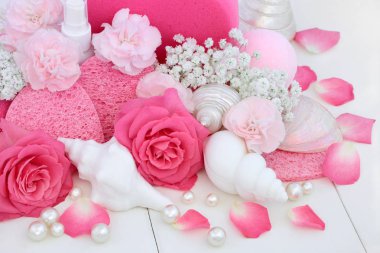Spa Güzellik tedavi ürünleri cleansing pembe gül ve karanfil çiçek, kabuk şeklinde sabunlar, banyo bomba, dekoratif kabukları ve inci üzerinde beyaz tahta arka plan ile süngerler.