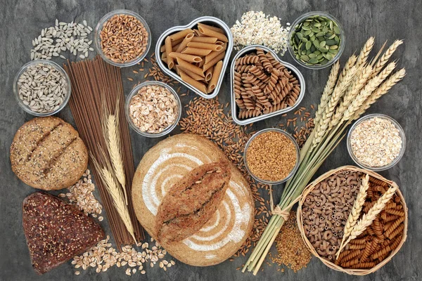 食品高全粒パンと食物繊維とシード ロール 全粒小麦のパスタ 大理石背景平面図上の粒 抗酸化物質 オメガ ビタミンの高い食品 — ストック写真