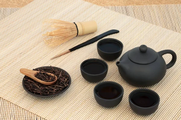 Kuchika のティーポットとカップ 攪拌竹背景に泡立て器と小枝緑茶ロースト 若返りのプロパティを含む多くの健康上の利点します — ストック写真