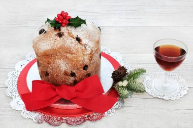 İtalyan panettone Noel kek ve holly, köknar ve ökseotu rustik ahşap masa arka plan üzerinde kış florası ile alkollü içki. Geleneksel tatlı ekmek.