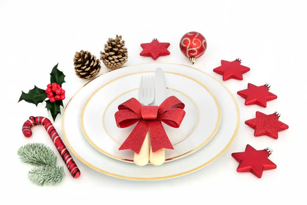 磁器の皿 カトラリー 赤い輝き弓 冬のヒイラギとモミ白い背景の上に安物の宝石装飾とクリスマス ディナーの場所の設定 — ストック写真