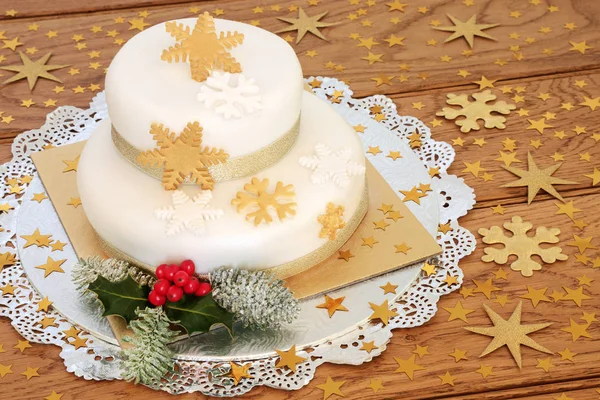 スノーフレークとゴールド スター装飾 冬のヒイラギとモミ オーク木材の背景と階層型 アイスの 層で豪華なクリスマス ケーキ — ストック写真