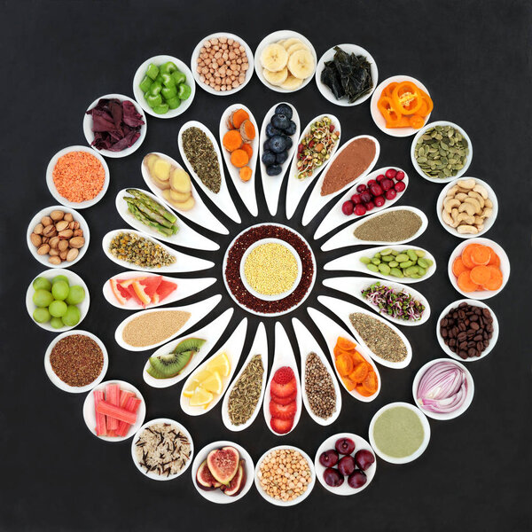 Large diet health food selection for weight loss on slate including vegetables, grains, nuts, seeds, supplement powders, spices and herbs used in herbal medicine to help with dieting and suppressing appetite. 