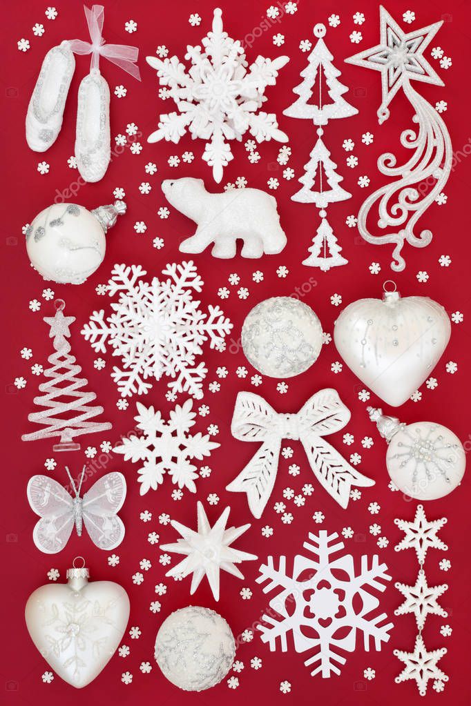 White and silver Christmas frosted bauble decorations on red background. Traditional Christmas greeting card for the holiday season. Top view.