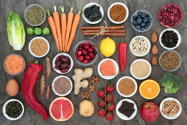 Super food to slow the ageing process concept with fish, fruit, vegetables, seeds, nuts, herbs, spices, supplement powders, green and black teas, high in antioxidants, anthocyanins, dietary fibre and vitamins.