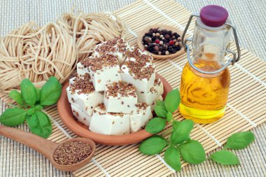 Veganlar için tofu fasulyesi lor yonca tohumu ve zeytinyağı ile karabiber, karabuğday erişte si fesleğen otu ile toz. Veganlar için sağlıklı yiyecekler. Yüksek protein ve omega 3, sekiz esansiyel amino asit içeren.