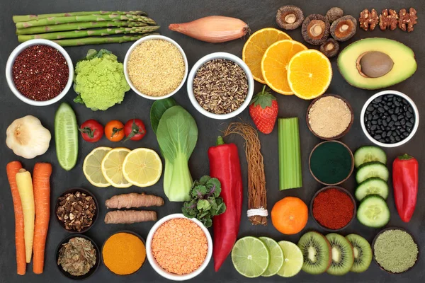 Diet health food for liver detox concept with fresh fruit, vegetables, herbal medicine, legumes, grains, seeds, herbs and spices. Foods high in antioxidants, omega 3, vitamins &  dietary fibre. Top view on slate.