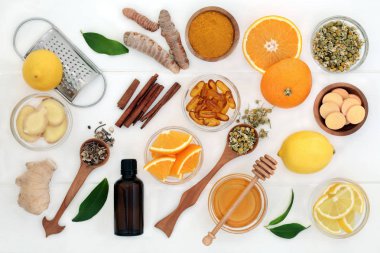 Zencefil, zerdeçal, Ekinezya, papatya ve tarçın, okaliptüs yağı, bal, vitamin tabletleri ve Beyaz ahşap üzerine portakal ve limon meyve kapsül ile soğuk algınlığı ve grip çare için malzemeler.