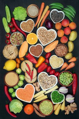 Protein, vitamin, mineral, antosiyanin, antioksidan, akıllı karbonhidrat ve diyet lifinin yüksek olduğu sağlıklı bir kalp konsepti için vegan yiyeceği. Düz, koyu renk ahşap zemin.