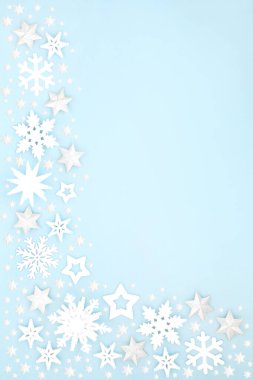 Beyaz yıldızlı Noel karları, pastel mavi arka planda kar tanesi ve top şeklinde süslemeler. Noel bayramı için Xmas & kış ve yeni yıl kompozisyonu. 