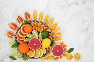 Tabaklarda portakal, limon, limon, mandalina ve greyfurt içeren yüksek miktarda antioksidan ve C vitamini içeren turunçgiller. Ayrıca yüksek oranda antosiyanin, likopene ve diyet lifleri. Sağlık hizmeti konsepti. Mermer arka planda,  