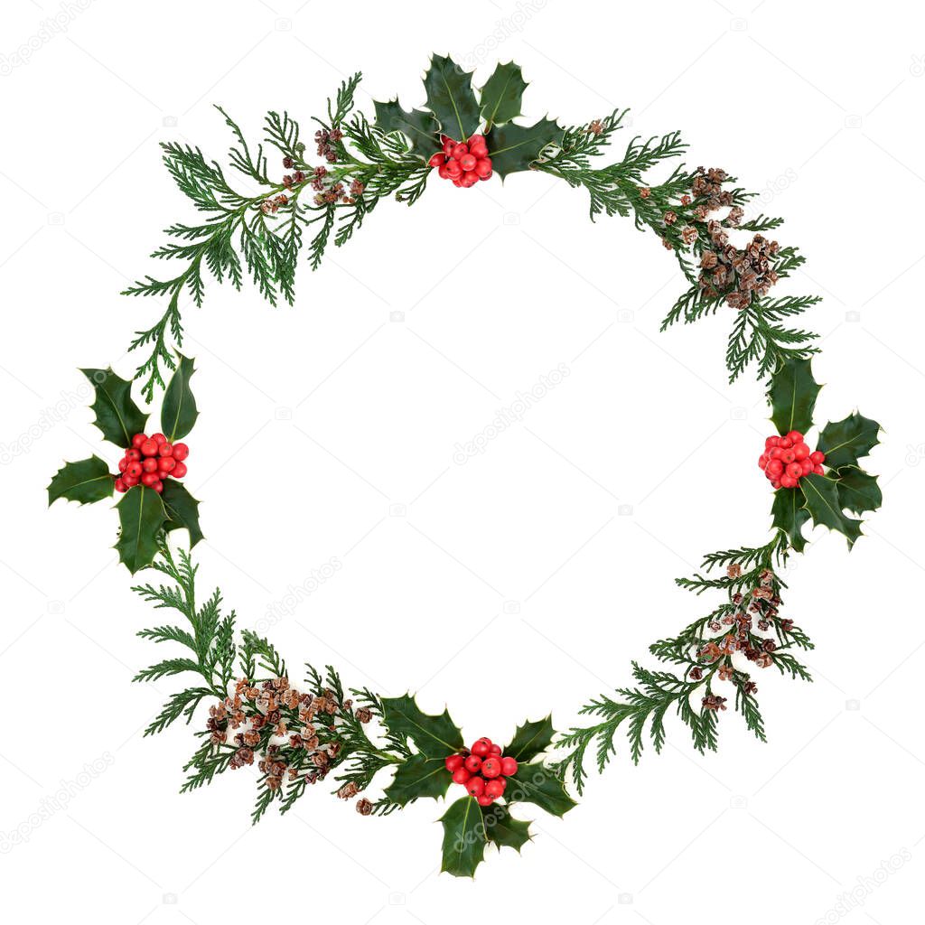 Winter cedar cypress & holly berry wreath on white background. Minimal composition for the Christmas holiday season & New Year themes. Flat lay, top view, copy space.
