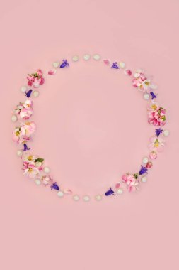 Minik yumurtalar, BlueBell çiçekleri ve elma çiçekli Paskalya çelengi. Pembe arka planda kart, logo, hediye etiketi veya davetiye için soyut tasarım.