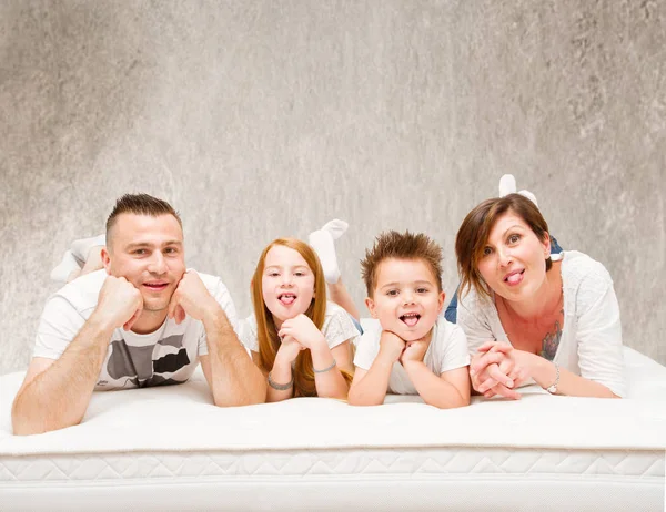 Lächelnde Familie Die Spaß Auf Dem Bett Hat — Stockfoto