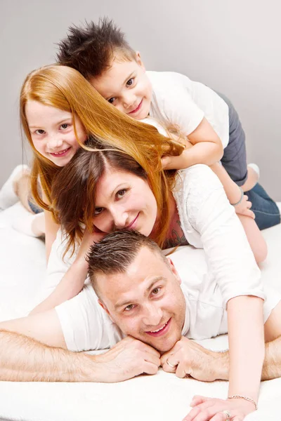 Sorrindo Família Divertindo Deitado Cama — Fotografia de Stock