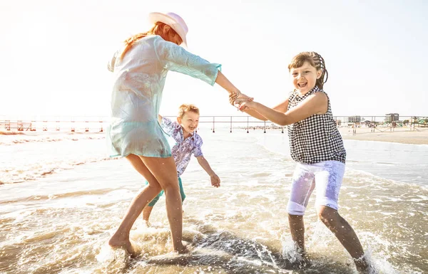 快乐的妈妈和她的孩子们一起玩海 — 图库照片